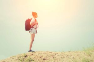 Teenage girl wearing glasses, carrying a backpack to the travel.